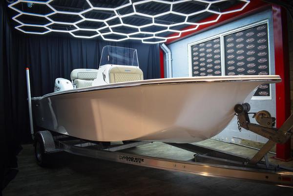 Slide: The Image of 2023 Savannah SS19 boat on trailer in showroom with modern lighting. - 0