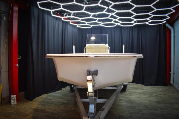 Slide: The Image of 2023 Savannah SS19 boat in showroom with modern hexagonal lighting. - 1