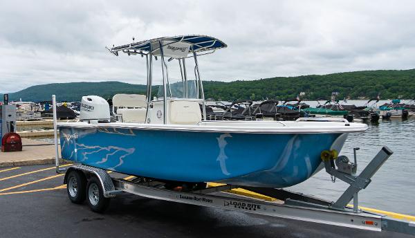 Slide: The Image of 2023 Savannah SS21 boat on trailer at marina with scenic background. - 0