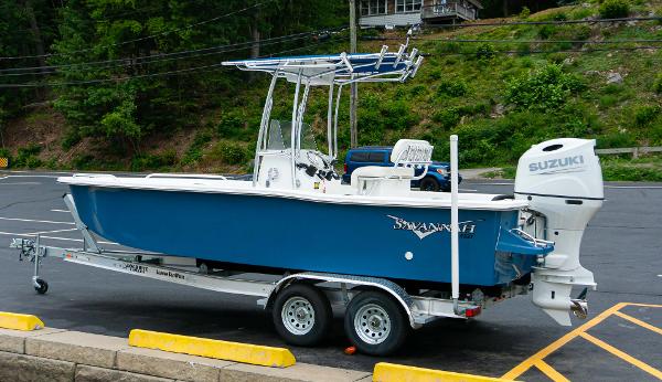 Slide: The Image of 2023 Savannah SS21 boat on trailer with Suzuki outboard motor in parking lot. - 1