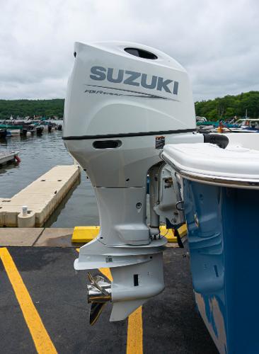 Slide: The Image of Outboard motor on a 2023 Savannah SS21 boat docked at a marina. - 16