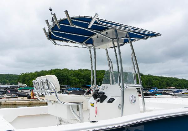 Slide: The Image of 2023 Savannah SS21 boat with T-top and center console at a marina. - 2