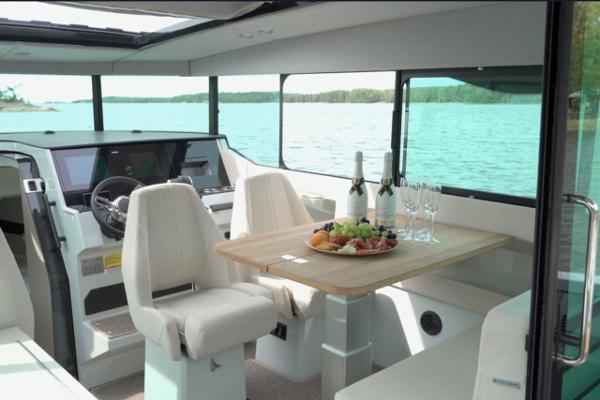 Slide: The Image of Interior of 2024 Saxdor 320 GTC yacht with dining table, champagne, and scenic water view. - 17