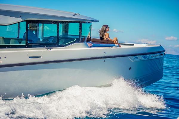 Slide: The Image of 2024 Saxdor 320 GTC cruising on the ocean with a woman relaxing on deck. - 3