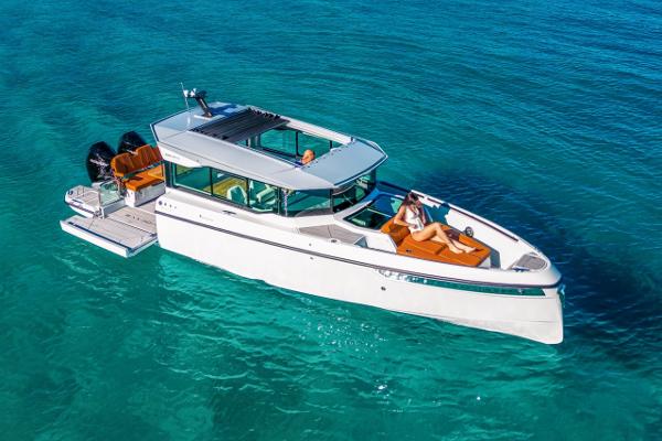 Slide: The Image of 2024 Saxdor 320 GTC luxury motorboat on clear blue water. - 4