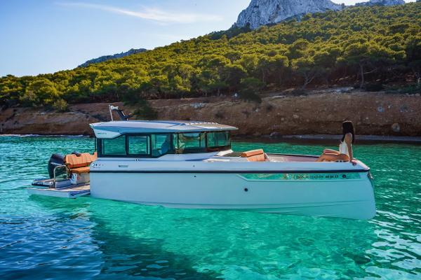 Slide: The Image of 2024 Saxdor 320 GTC boat in clear turquoise water near a forested coastline. - 5
