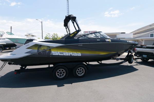 Slide: The Image of 2017 Scarab 255 HO Impulse boat on a trailer in a parking lot. - 1