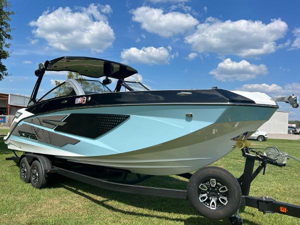 Slide: The Image of 2024 Scarab 285 ID boat on a trailer under a blue sky with clouds. - 0