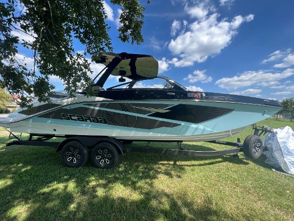Slide: The Image of 2024 Scarab 285 ID boat on a trailer under a sunny sky. - 10