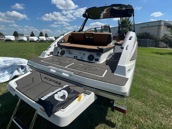 Slide: The Image of 2024 Scarab 285 ID boat with swim platform and seating, displayed on grass. - 12