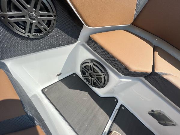 Slide: The Image of 2024 Scarab 285 ID boat interior with brown seating and black speakers. - 18