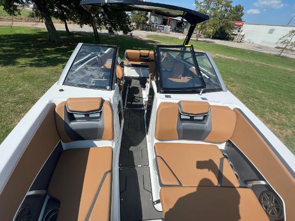 Slide: The Image of 2024 Scarab 285 ID boat with tan and gray interior, docked on grassy area. - 20