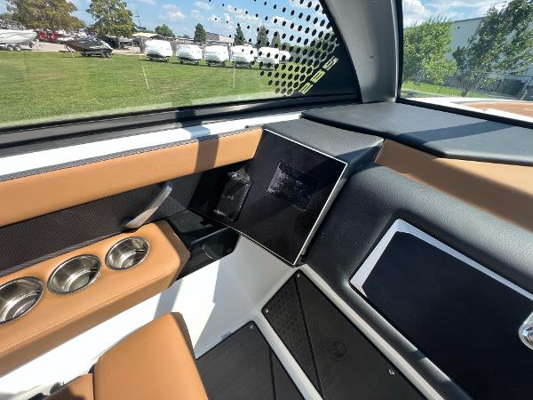 Slide: The Image of 2024 Scarab 285 ID boat interior with tan and black accents, modern dashboard, and cup holders. - 28