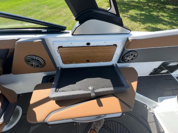Slide: The Image of 2024 Scarab 285 ID boat interior with open storage compartment and brown seating. - 31