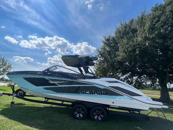 Slide: The Image of 2024 Scarab 285 ID boat on a trailer under a sunny sky. - 35
