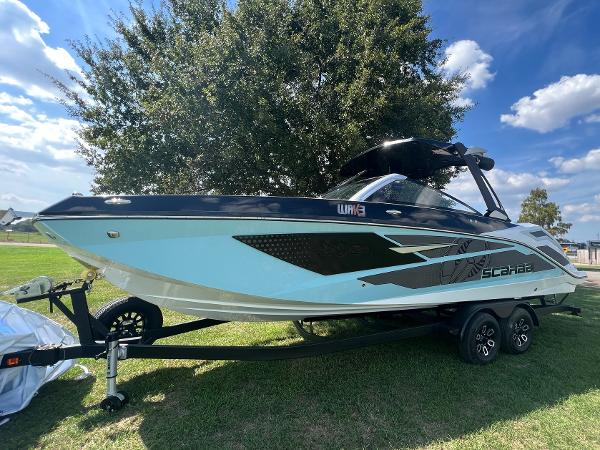 Slide: The Image of 2024 Scarab 285 ID boat on a trailer, parked on grass under a sunny sky. - 6