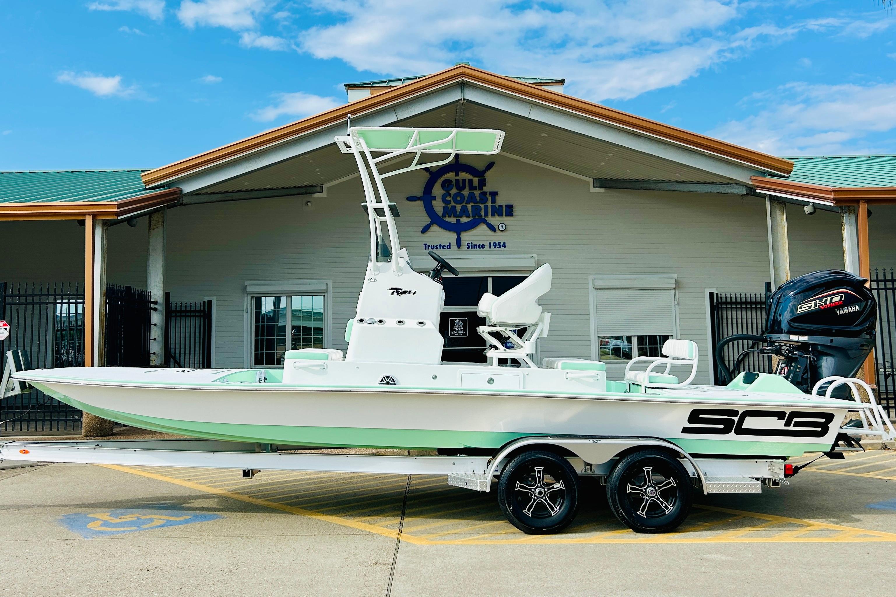 Slide: The Image of 2026 SCB R24 boat on trailer at Gulf Coast Marine dealership. - 0