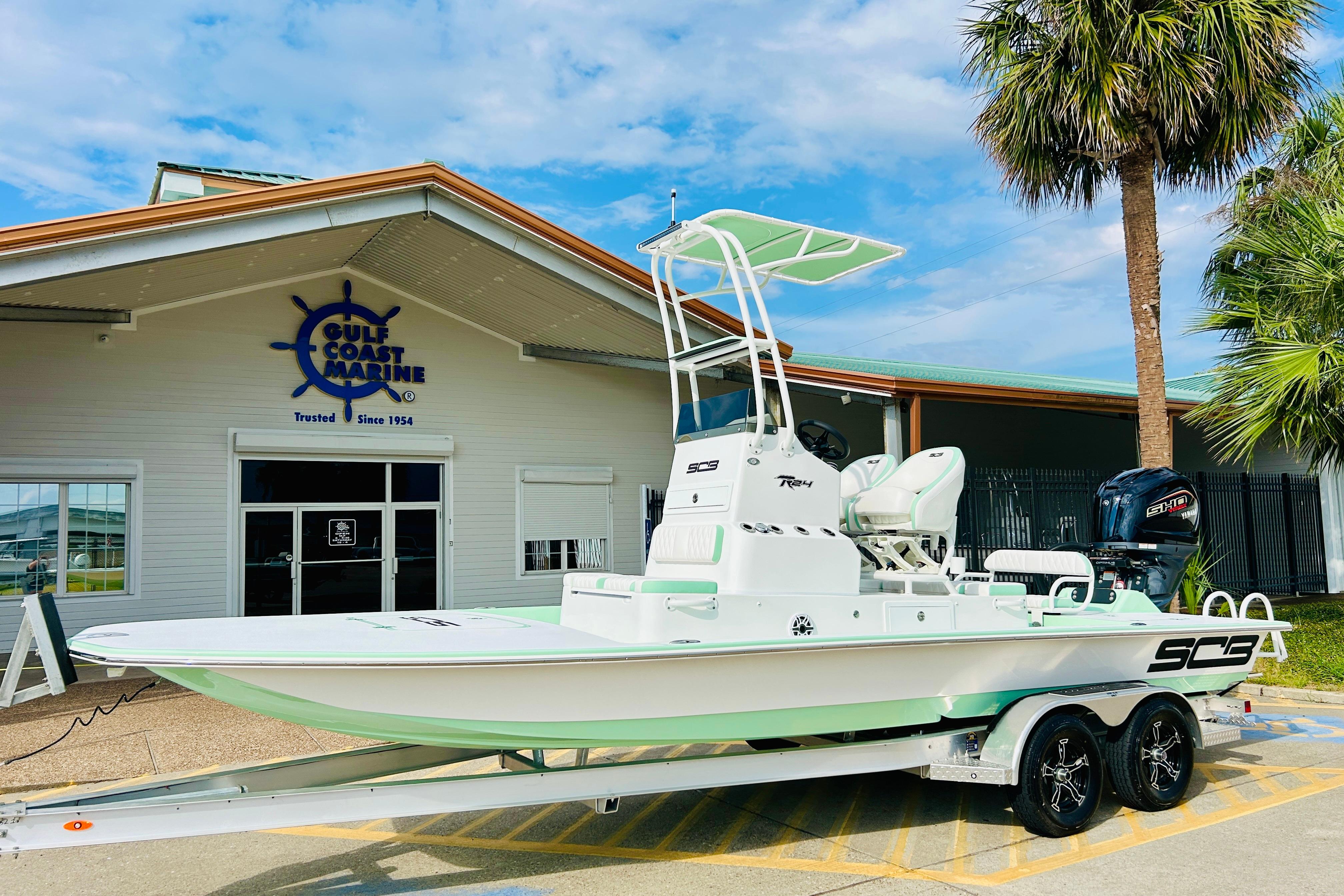 Slide: The Image of 2026 SCB R24 boat on trailer at Gulf Coast Marine dealership. - 1