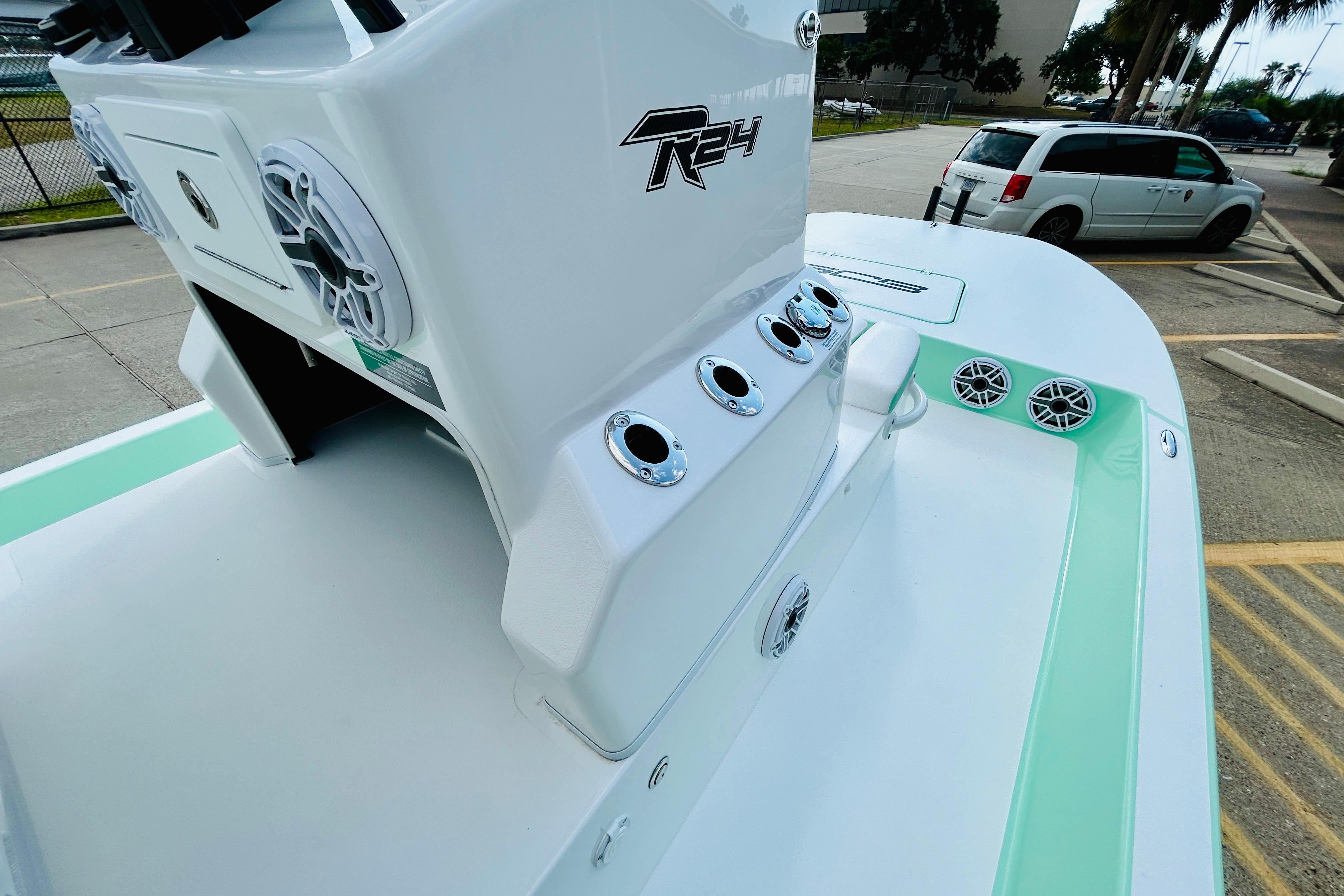 Slide: The Image of 2026 SCB R24 boat with sleek design and modern features, parked outdoors. - 13