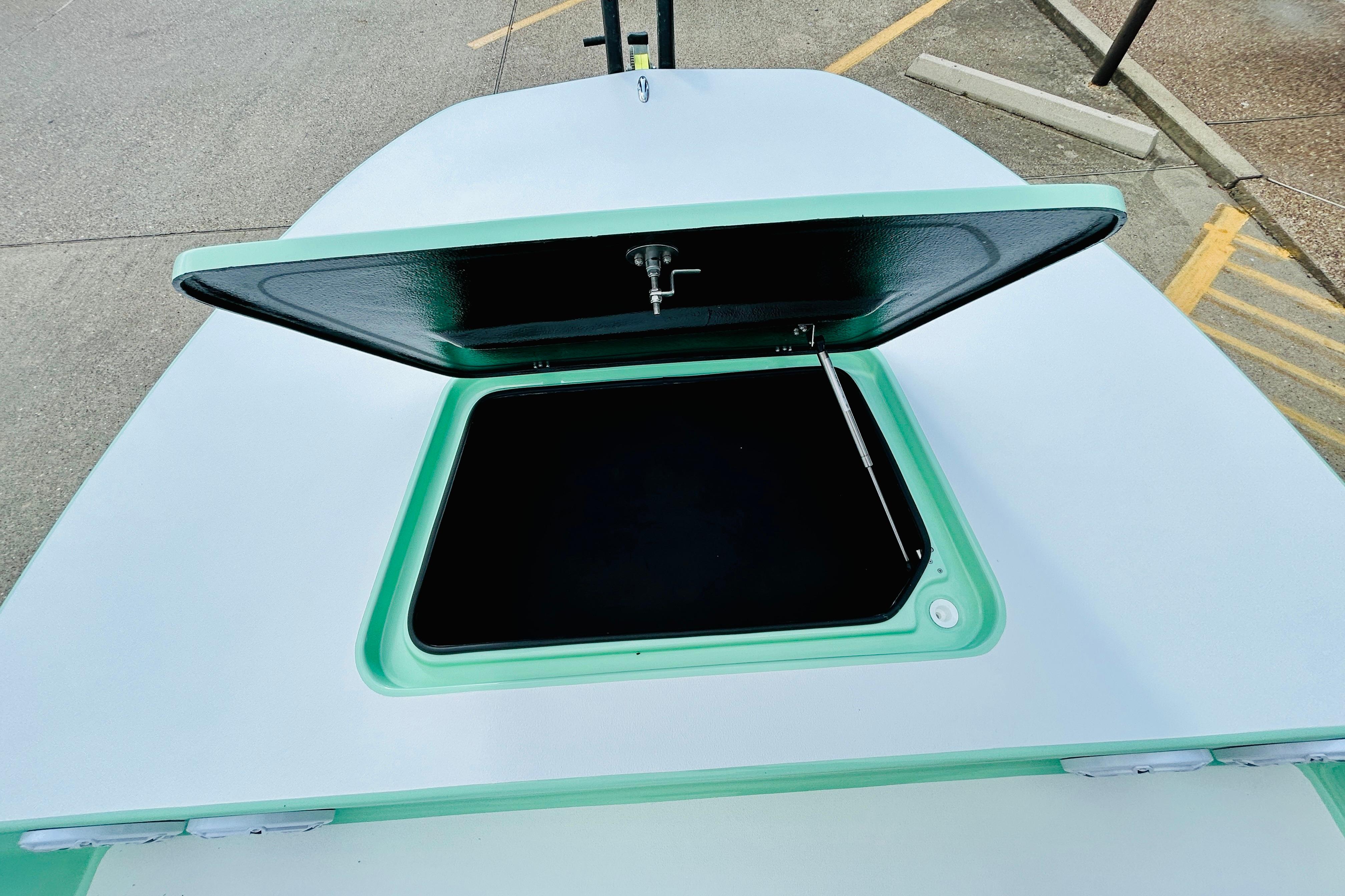 Slide: The Image of Open hatch on 2026 SCB R24 boat deck, showcasing storage compartment. - 15