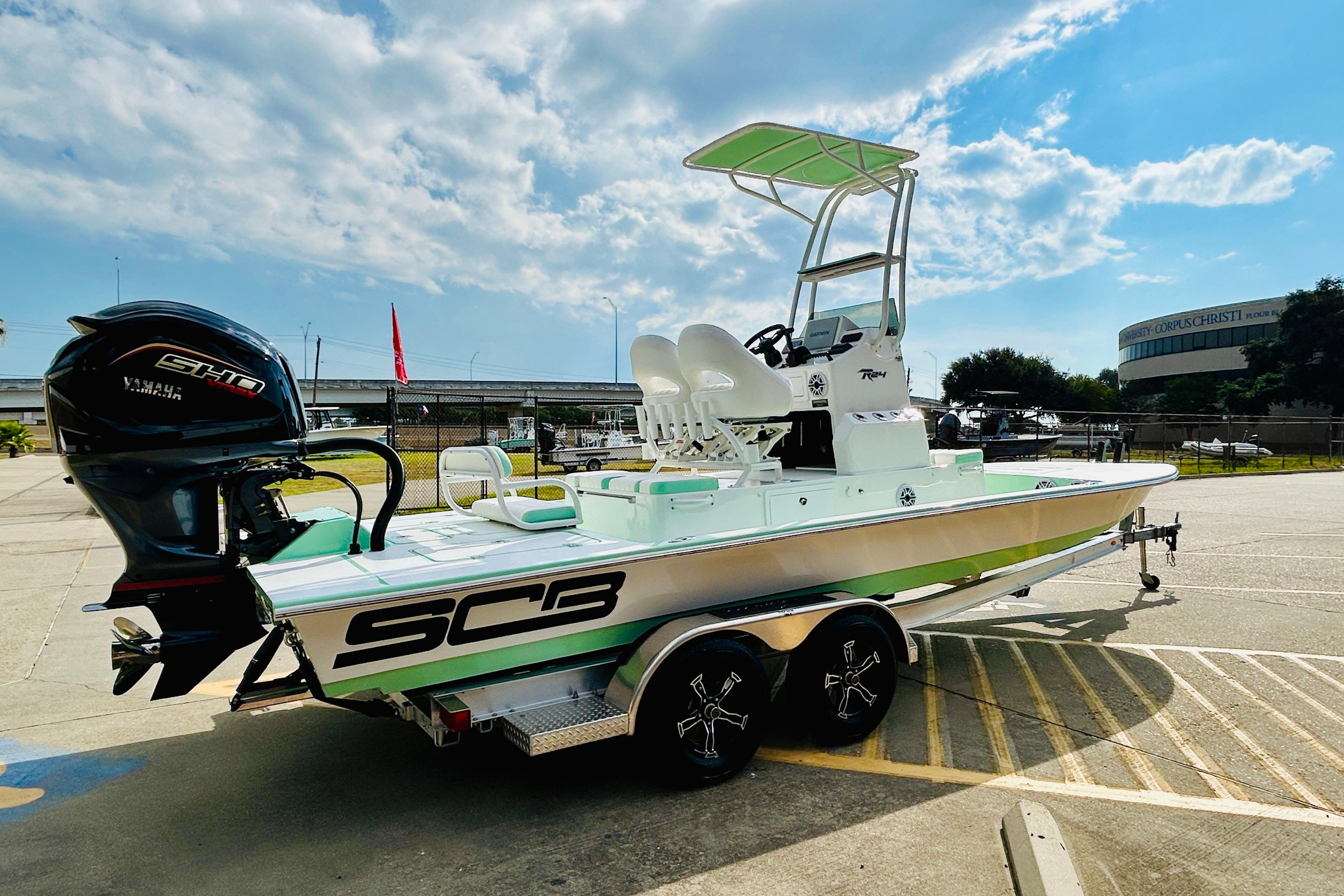 Slide: The Image of 2026 SCB R24 boat with Yamaha engine on trailer, parked outdoors under a cloudy sky. - 4