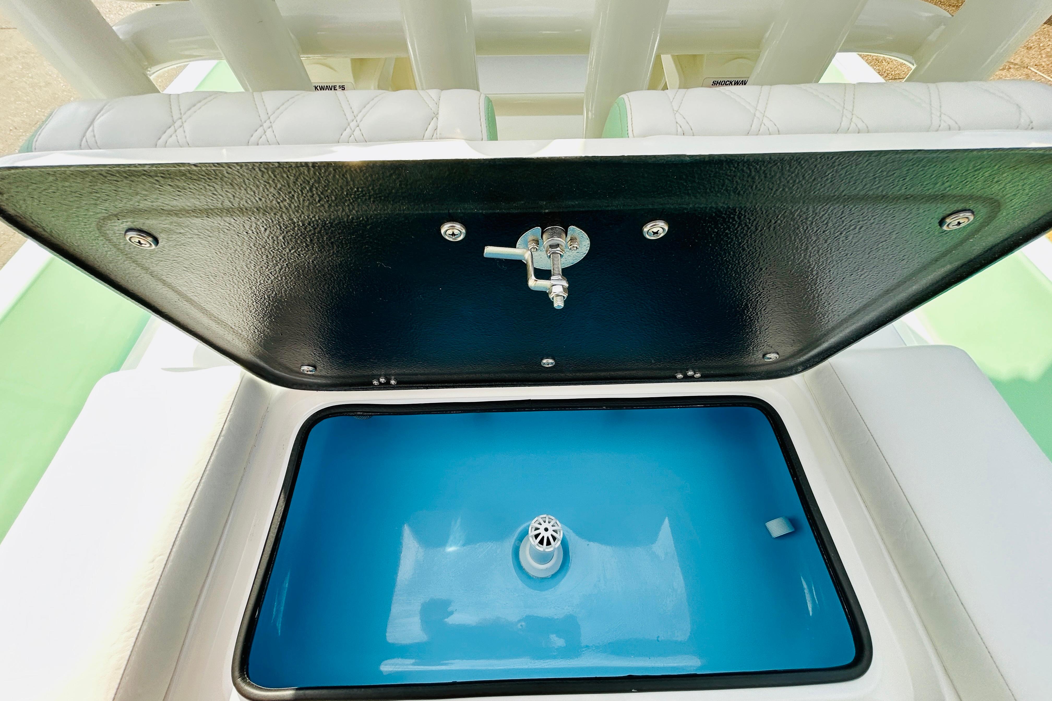 Slide: The Image of 2026 SCB R24 boat livewell with open lid, showcasing blue interior and drain. - 9