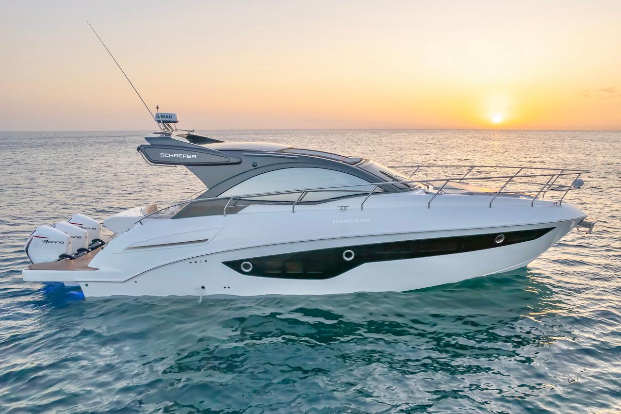 Slide: The Image of 2025 Schaefer 400 Sport yacht cruising at sunset on the ocean. - 0