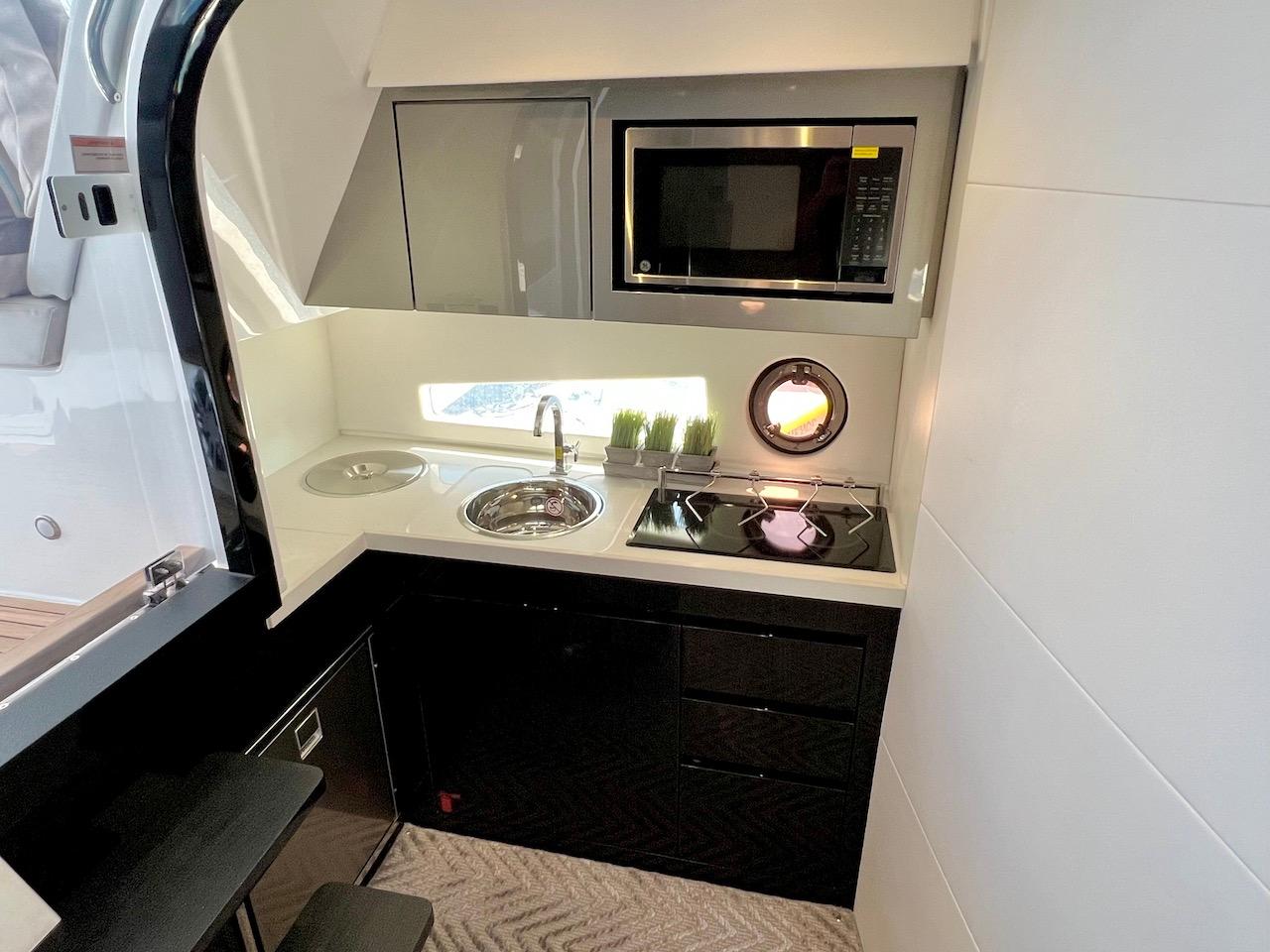 Slide: The Image of Modern kitchen in 2025 Schaefer 400 Sport yacht with microwave, sink, and stove. - 17