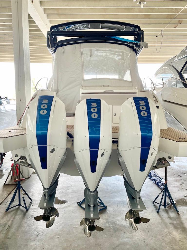 Slide: The Image of 2025 Schaefer 400 Sport boat with triple outboard engines in a covered dock. - 42