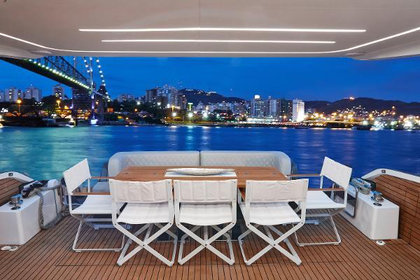 Slide: The Image of Luxury Schaefer 600 yacht deck with city skyline view at night, 2024 model. - 12