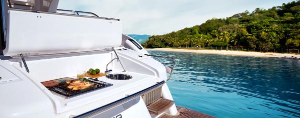 Slide: The Image of Schaefer 600 yacht 2024 model with outdoor grill, anchored near tropical island. - 6