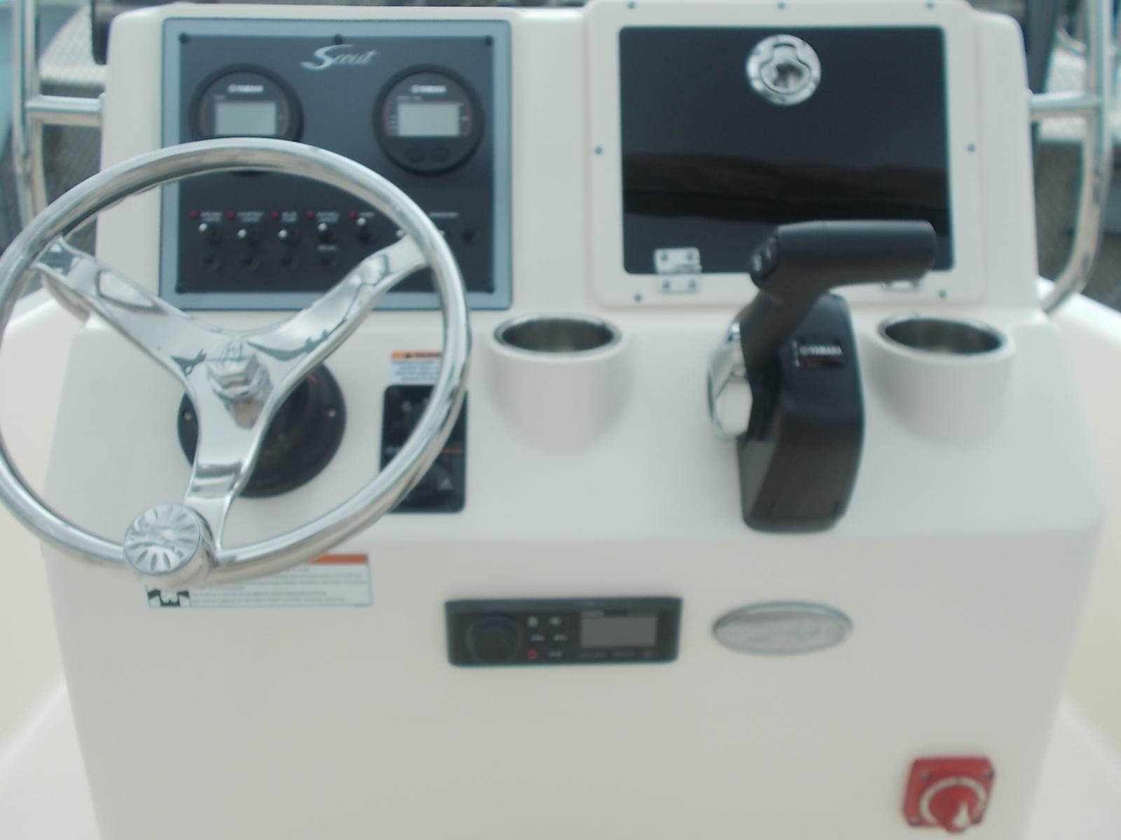 Slide: The Image of 2025 Scout 175 Sportfish boat dashboard with steering wheel and control panel. - 1