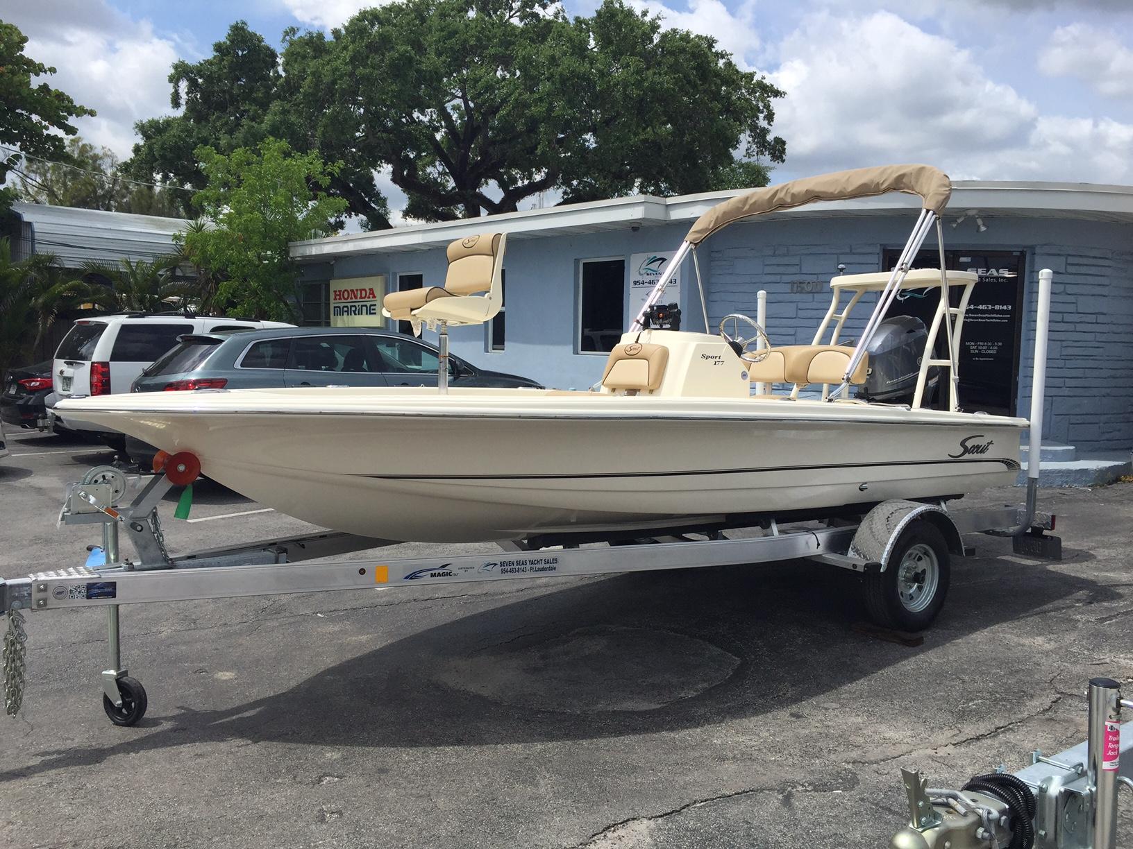 Slide: The Image of 2025 Scout 177 Sport boat on a trailer in a dealership parking lot. - 0