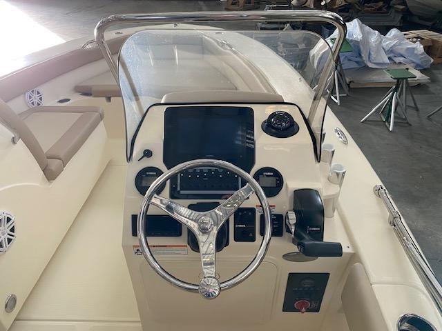 Slide: The Image of 2024 Scout 195 Sport Dorado boat dashboard with steering wheel and control panel. - 5