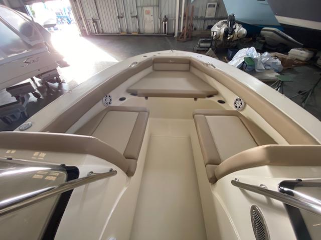 Slide: The Image of 2024 Scout 195 Sport Dorado boat interior with beige seating in a storage facility. - 8