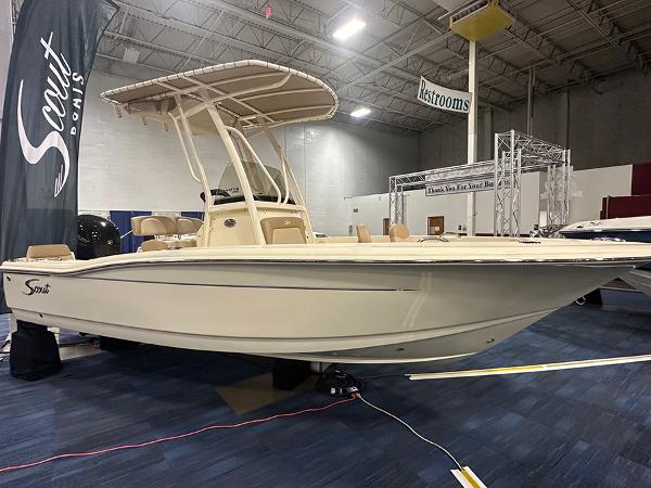 Slide: The Image of 2024 Scout 195 Sportfish boat displayed indoors at a showroom. - 0
