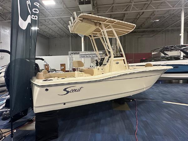 Slide: The Image of 2024 Scout 195 Sportfish boat displayed indoors, featuring a sleek design and modern amenities. - 1