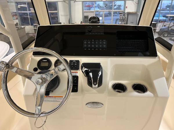 Slide: The Image of 2024 Scout 215 XSF boat dashboard with steering wheel and control panel. - 2