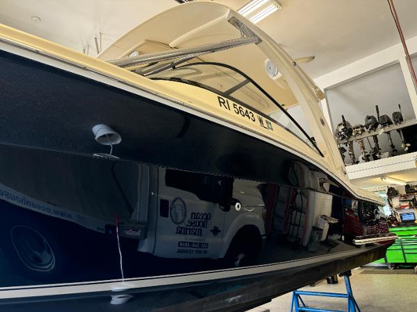 Slide: The Image of 2014 Scout 275 Dorado boat in a garage, side view with registration number RI 5643. - 8