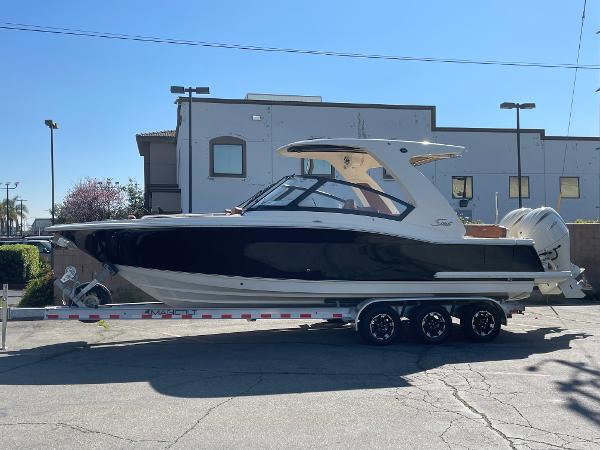 Slide: The Image of 2024 Scout 277 Dorado boat on a trailer in a parking lot. - 0