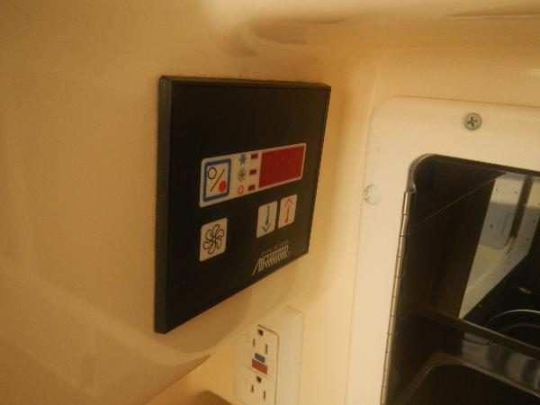 Slide: The Image of Control panel inside 2001 Scout 282 Abaco boat, featuring various function buttons and an outlet. - 18
