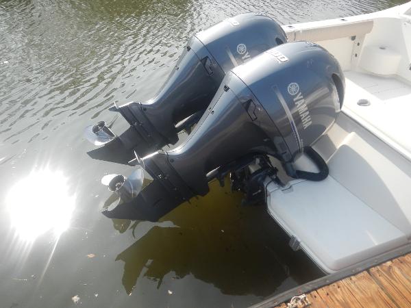 Slide: The Image of Twin Yamaha outboard engines on a 2001 Scout 282 Abaco boat, docked in calm water. - 25