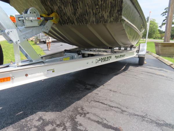 Slide: The Image of 2025 SeaArk 2072 FXT boat on Load Rite trailer, parked on asphalt. - 15