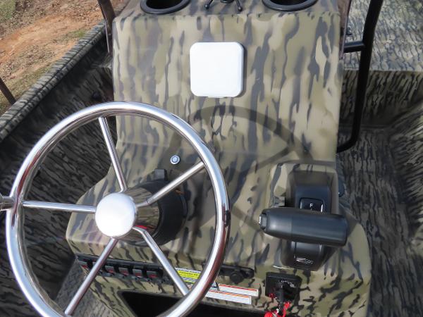 Slide: The Image of 2025 SeaArk 2072 FXT boat console with camouflage design and steering wheel. - 23