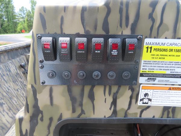 Slide: The Image of Control panel of 2025 SeaArk 2072 FXT boat with various switches and capacity label. - 3