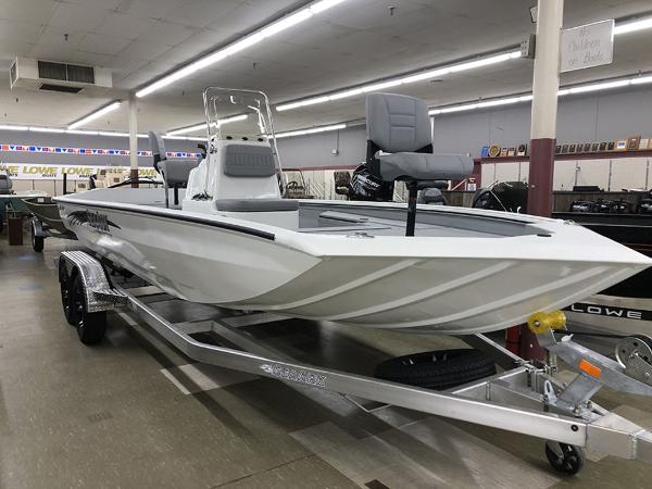 Slide: The Image of 2023 SeaArk BXT220 Bay Tunnel boat displayed indoors on a trailer. - 2