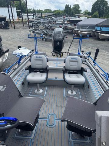 Slide: The Image of 2023 SeaArk Pro Cat 240 boat with seating and fishing setup, parked in a marina. - 14