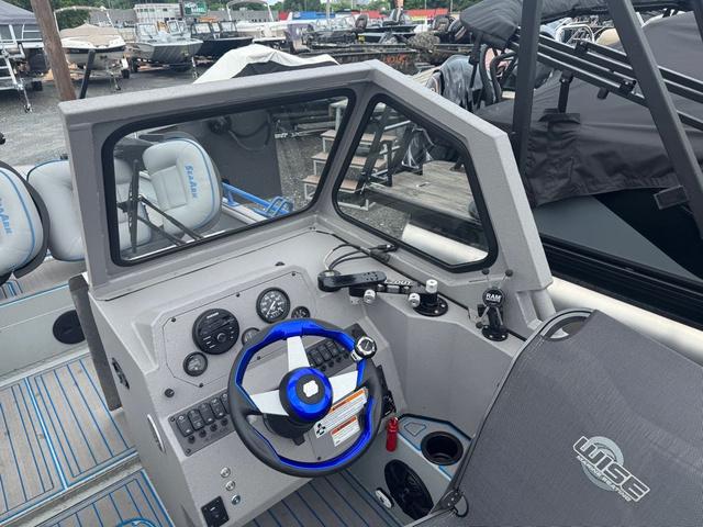 Slide: The Image of 2023 SeaArk Pro Cat 240 boat cockpit with steering wheel and control panel. - 9