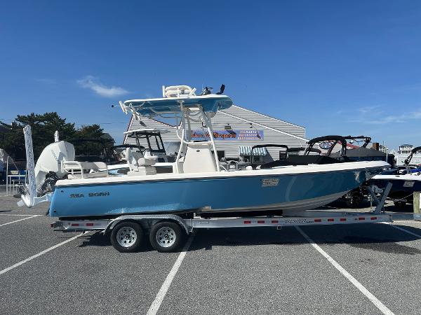 Slide: The Image of 2024 Sea Born FX25 Bay boat on a trailer in a parking lot. - 1