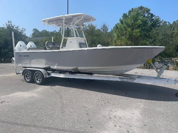 Slide: The Image of 2024 Sea Born LX 24 boat on a trailer in a parking lot. - 2